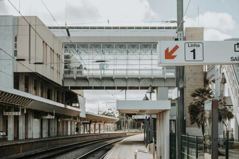 a train station with an overhead walkway on the left