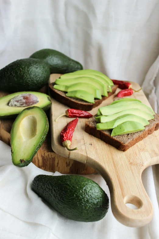 a table with three avocados on it, two open halves and one half eaten