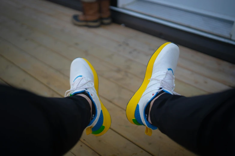 feet showing with colorful shoes and wood plank flooring