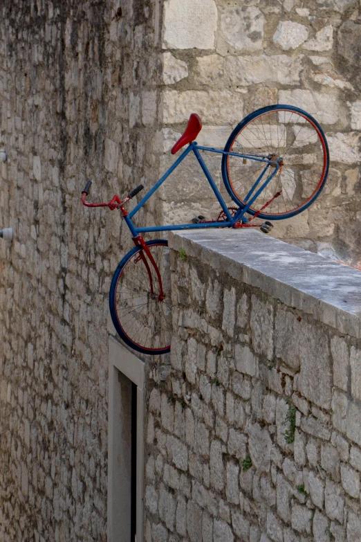 a blue bicycle is on the back of a building