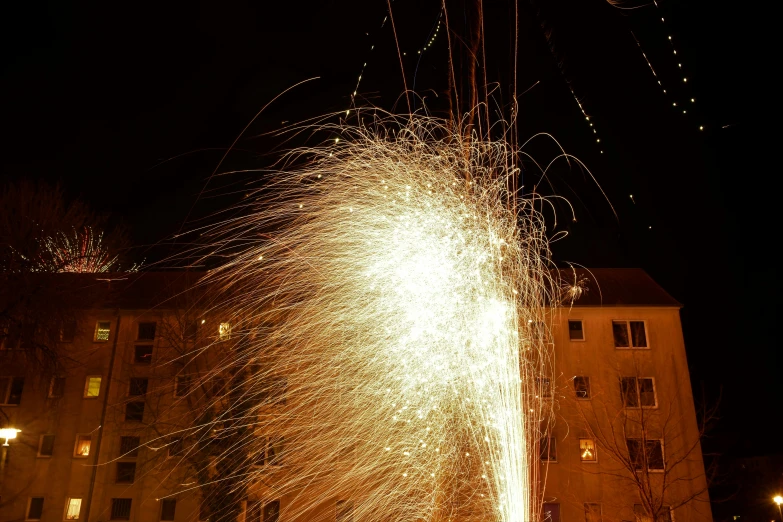 fireworks fly around a large el building at night