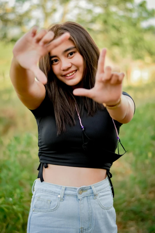 a girl posing for a picture making a peace sign