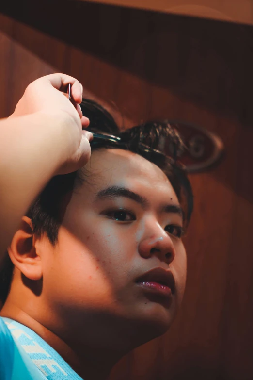 a young man is getting his hair cut by another young person