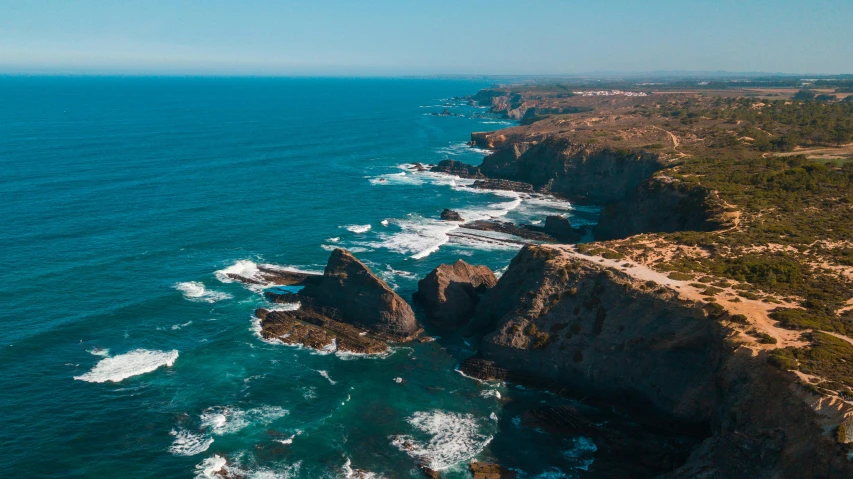 a view of the ocean and a cliff near the beach