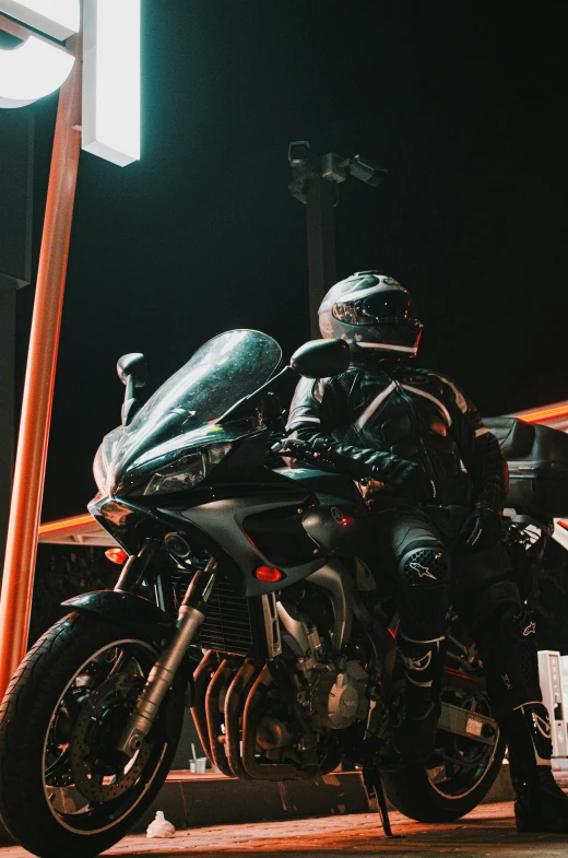 two people riding motorcycles, one wearing a helmet and the other wearing gloves