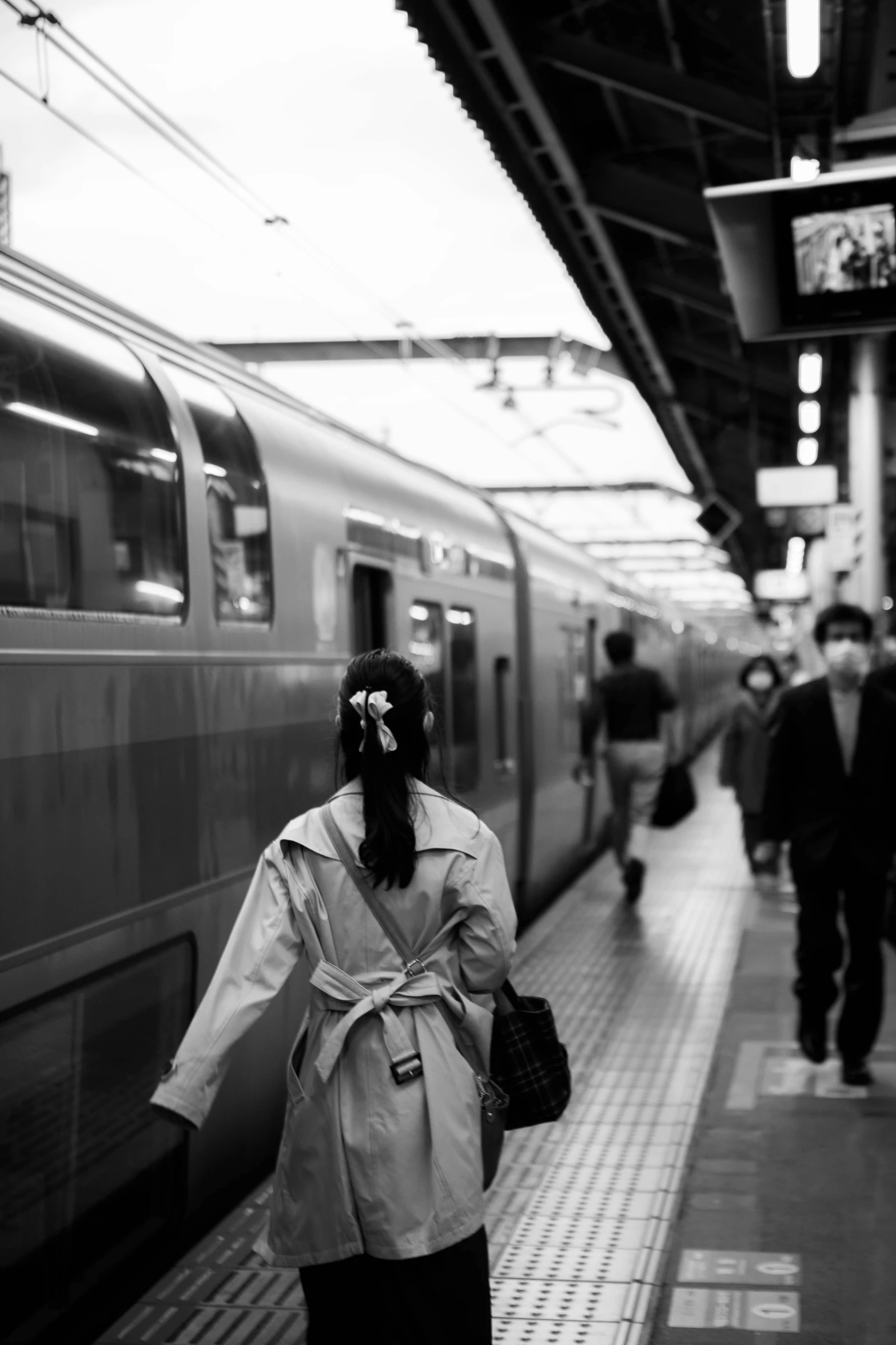 a woman walking towards a train on the platform