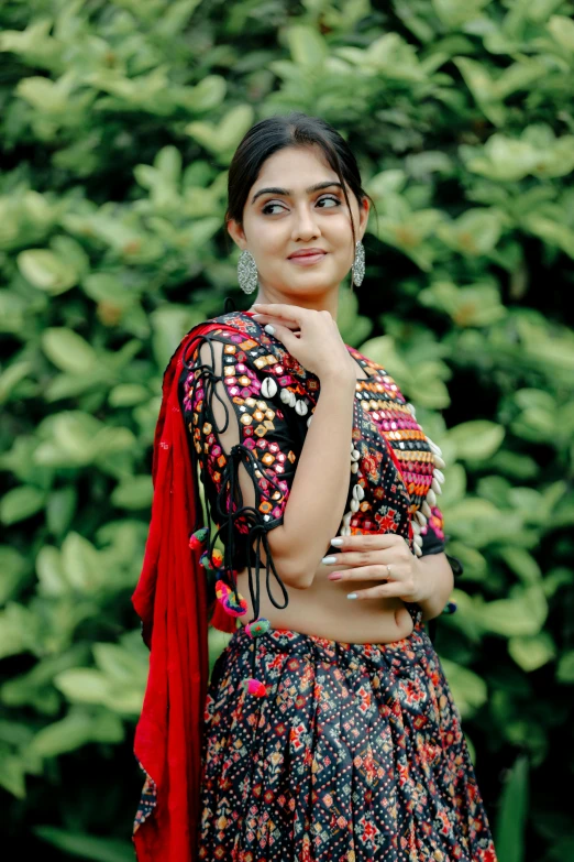 a beautiful young woman in a black dress standing with her arms folded