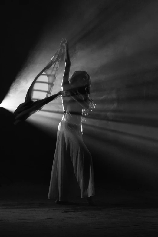 black and white image of woman in evening dress holding tennis racket