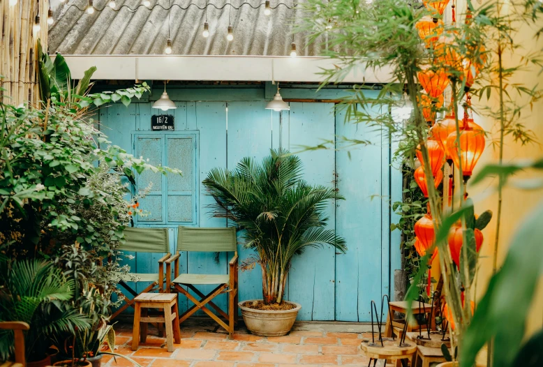 blue doors with plants and a couple chairs next to it