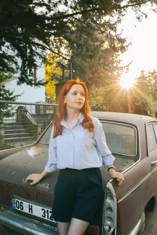 a woman leaning on the back of a car