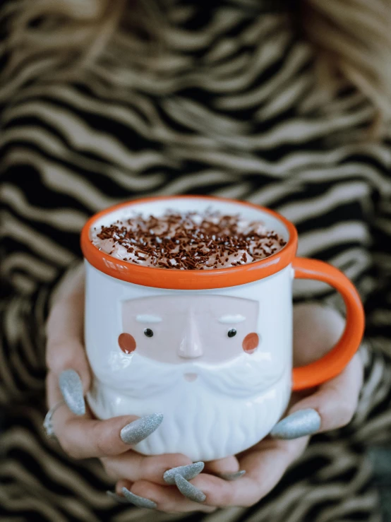 a person holding a cup filled with  cocoa