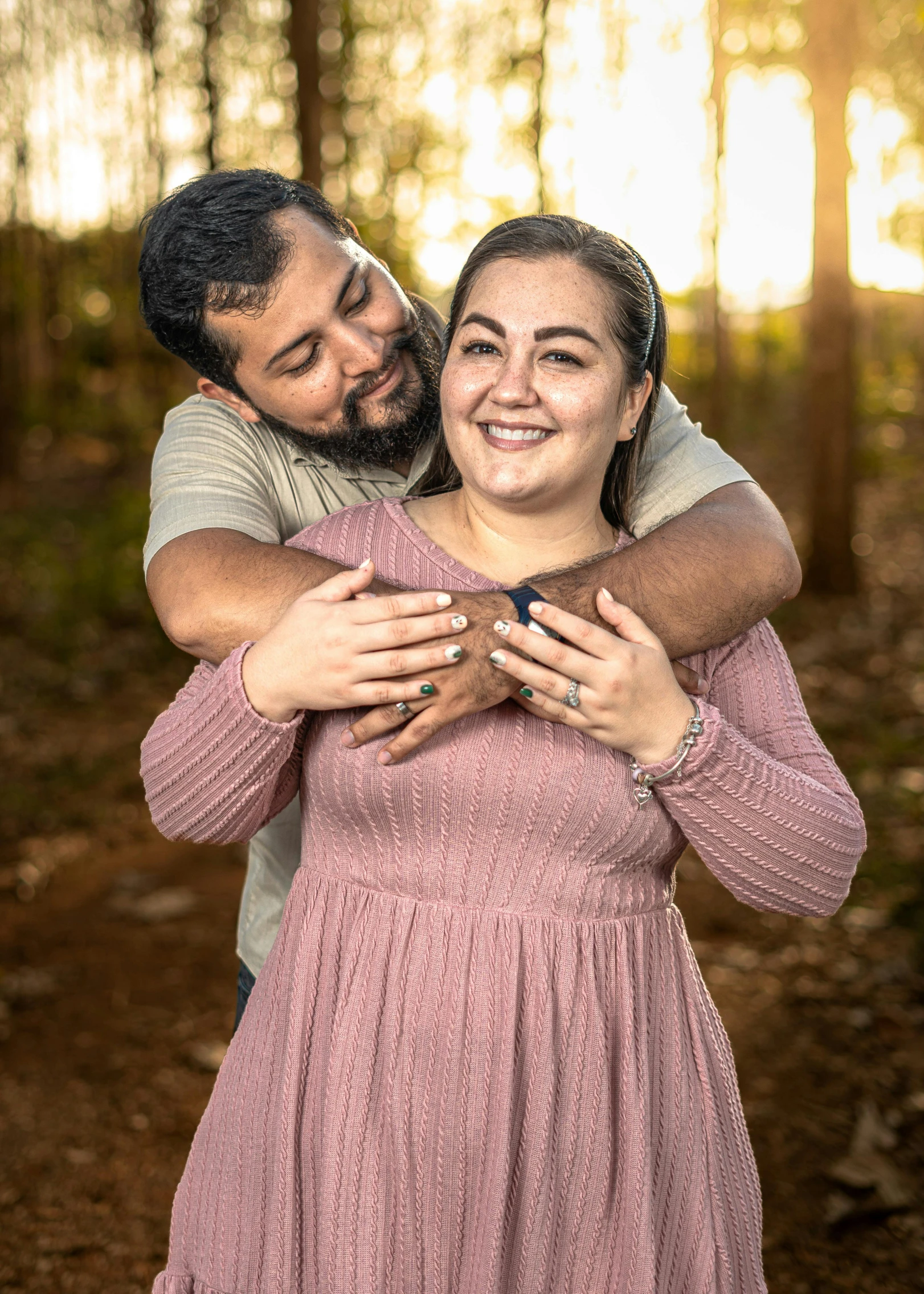 a happy couple emce each other in the woods