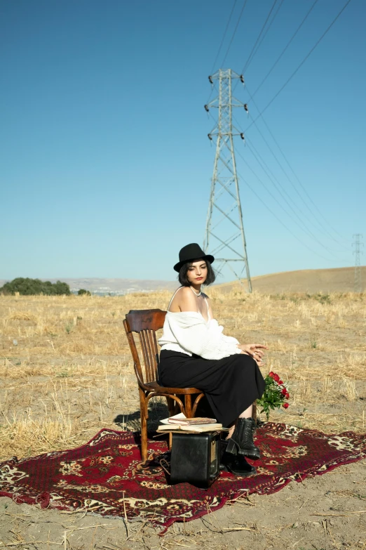 a woman in white shirt sitting on wooden chair on red rug