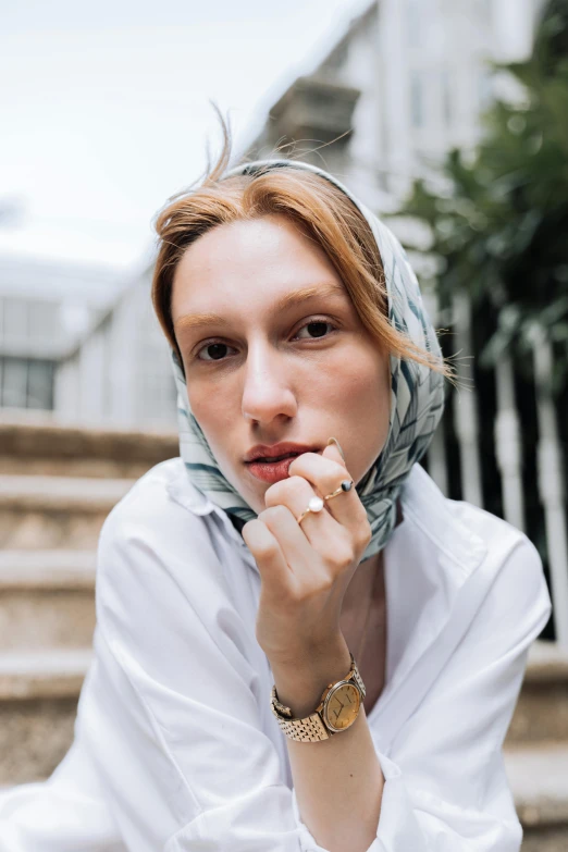 a young woman posing for a po on steps wearing a headscarf