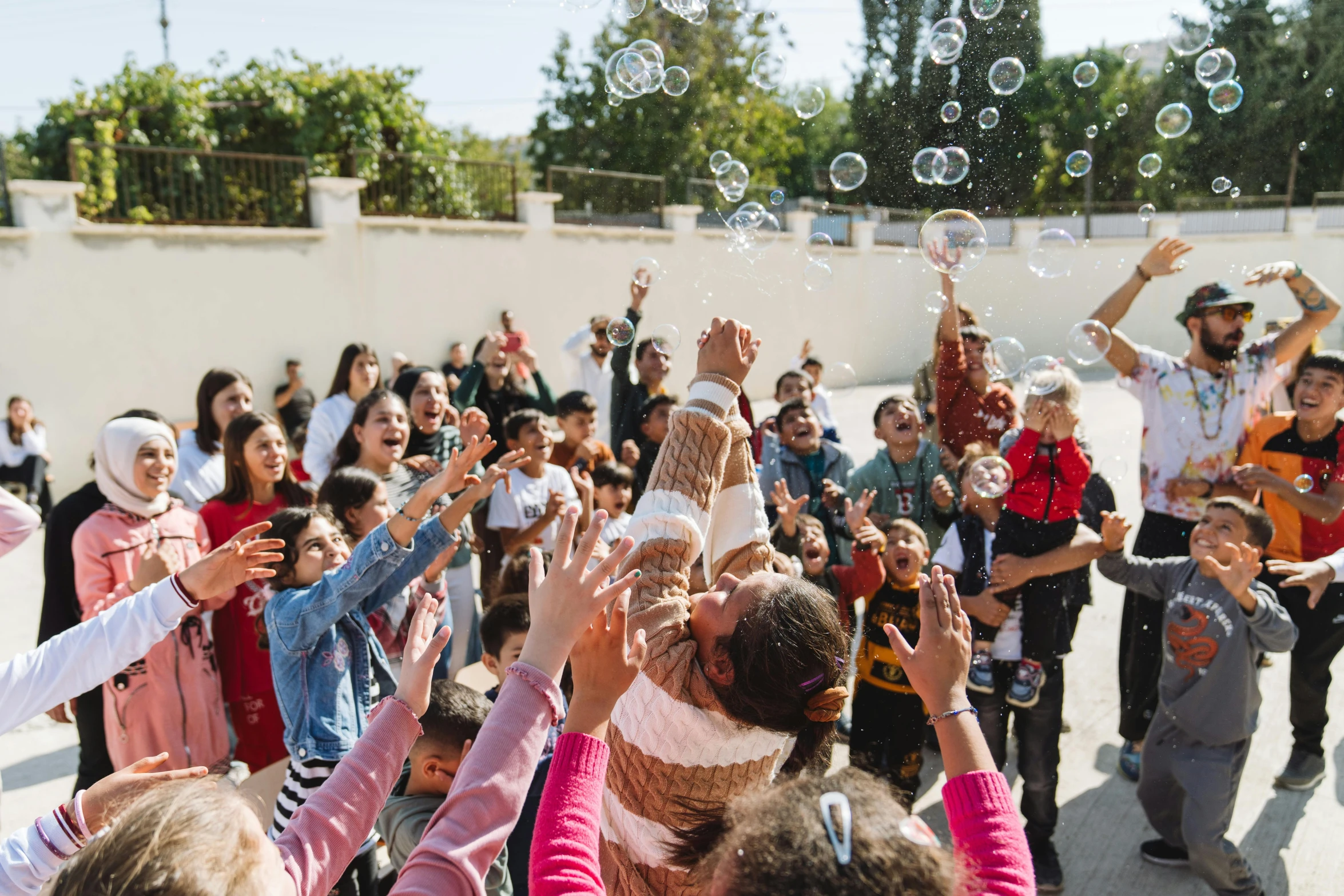 a group of people are gathered outside throwing soap