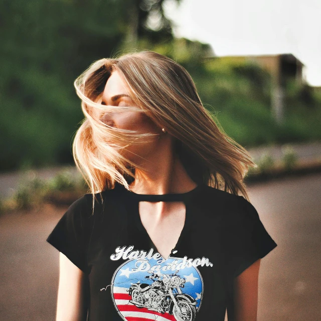 a woman looking up while wearing a black shirt with an american flag heart