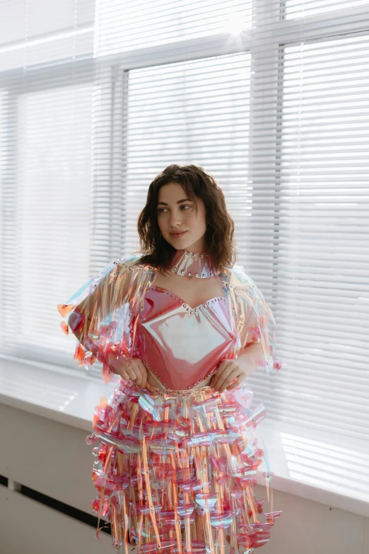 a woman dressed in colorful clothing standing in front of a window