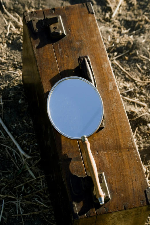 a magnifying glass on the side of an old piece of wood