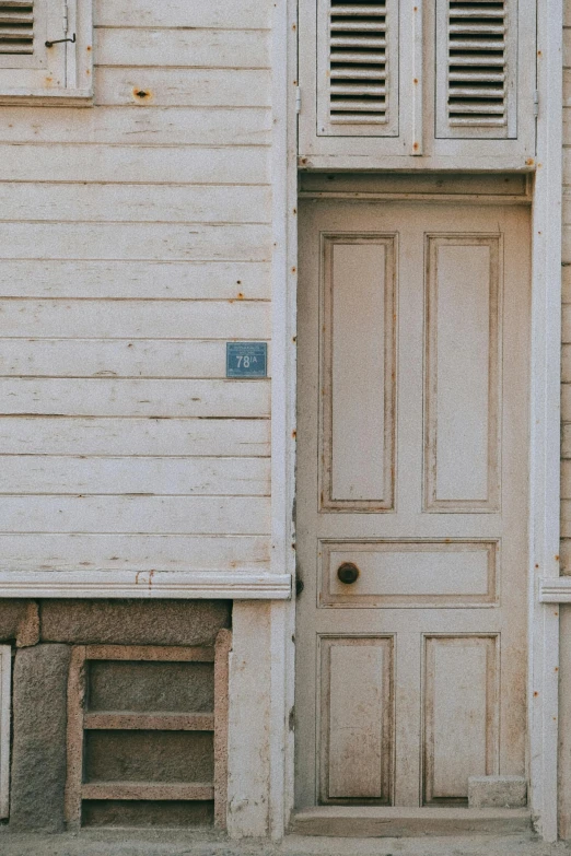 the side of a building with two doors and a number pad on it