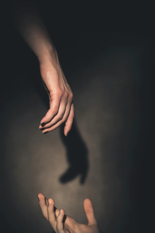 a po of a hands holding a hand that is sticking out from behind it