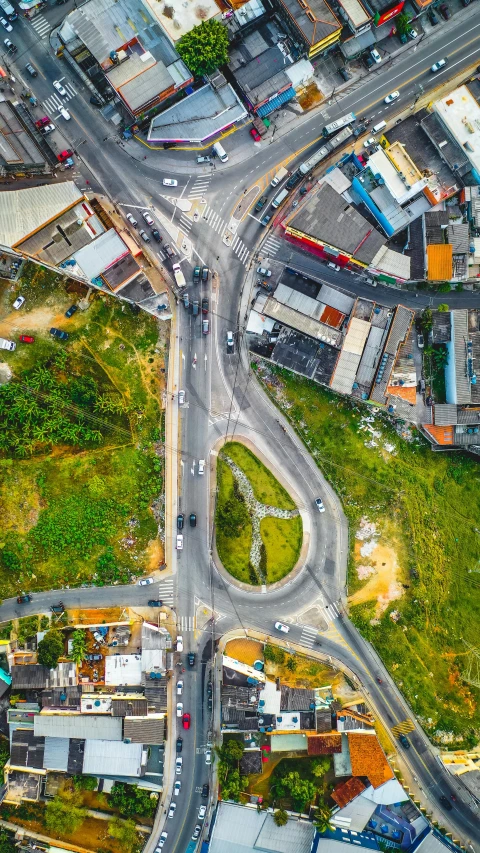 a wide intersection is seen with traffic in this aerial view