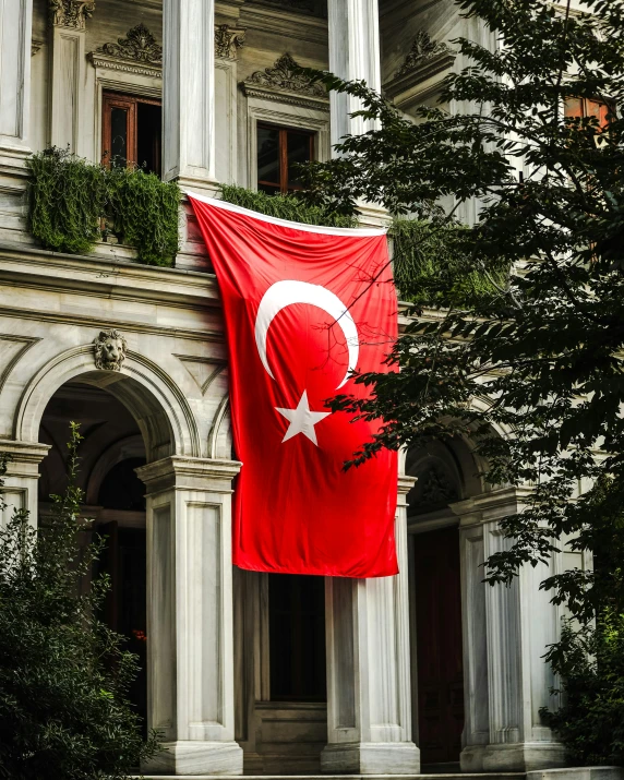the large turkey flag is hanging near the huge building