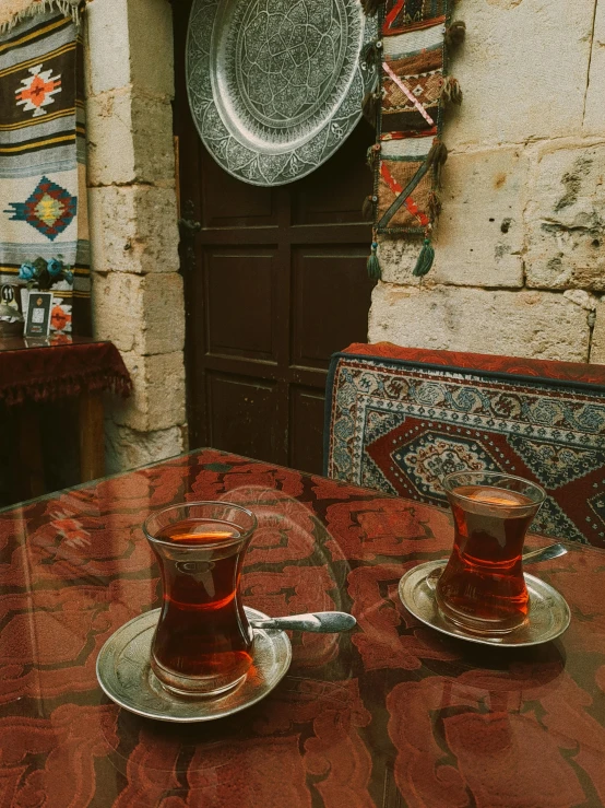 two cups filled with tea sitting on top of a table