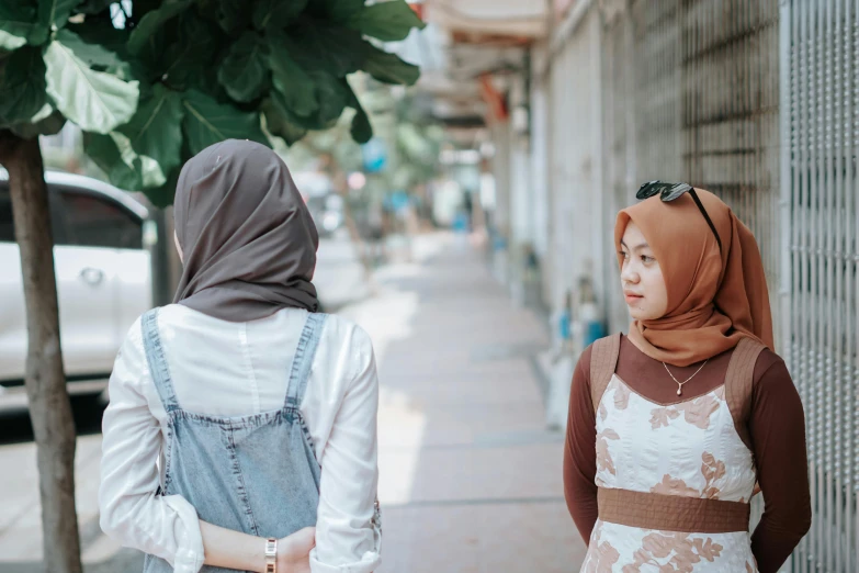 two woman with scarves walking down the street