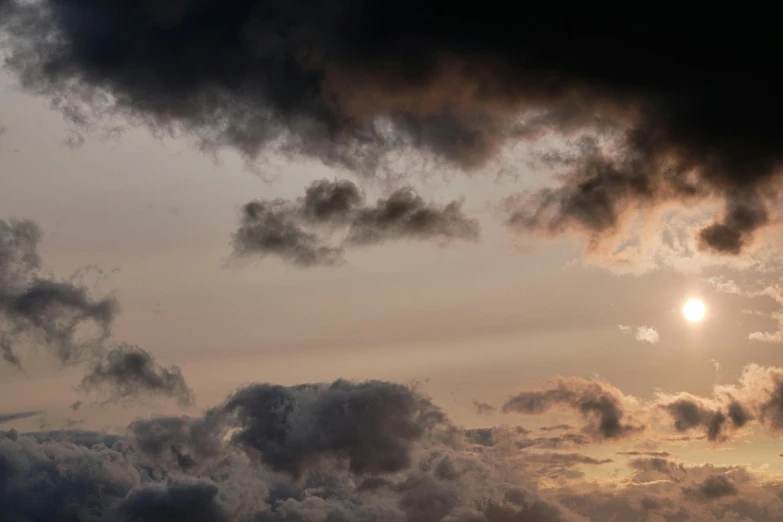 the sun is shining behind some dark clouds