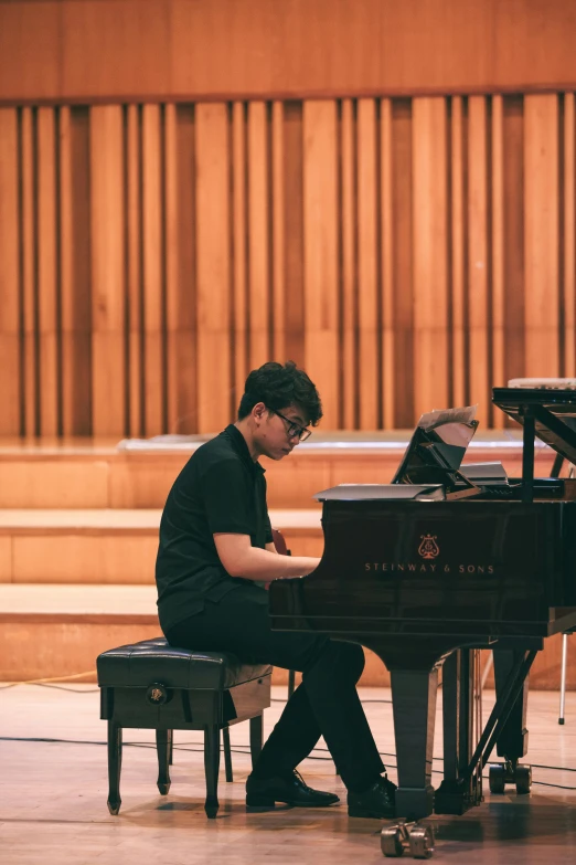 a man is sitting at a piano in the hall