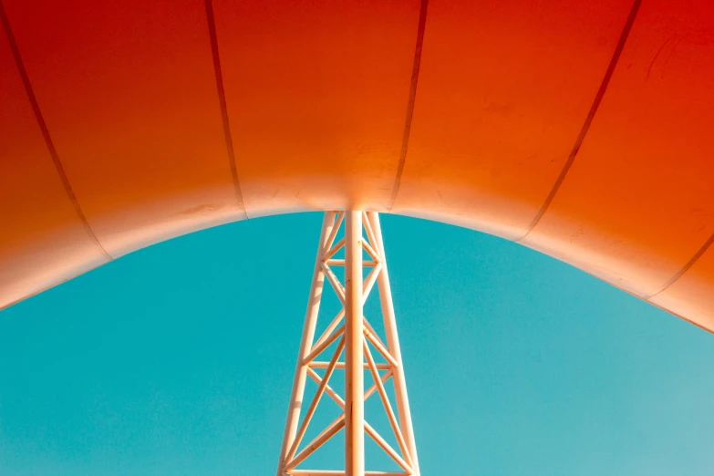 an orange umbrella on top of a tall tower