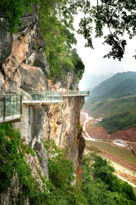 people are walking on a bridge over rocks