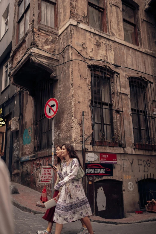 a woman walking down a city street past an old building