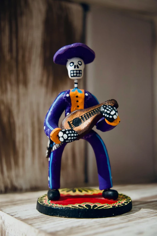 a plastic toy with a guitar is posed