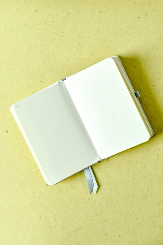 a notebook open on a table with one end sticking out