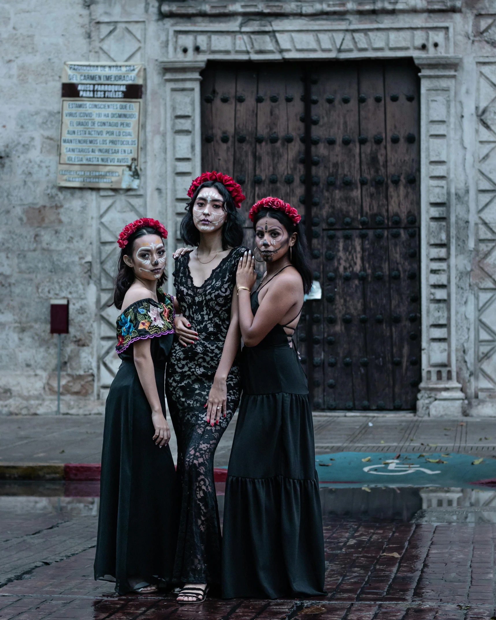 three women in long dresses stand next to each other