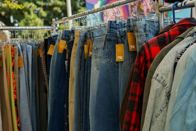 several pairs of blue jeans are on sale at a market