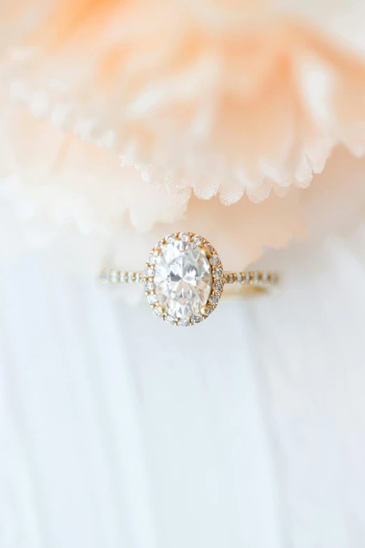 a white and gold ring with a round diamond