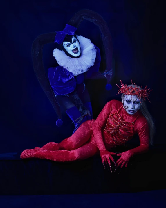two clowns with makeup and costumes posing for the camera