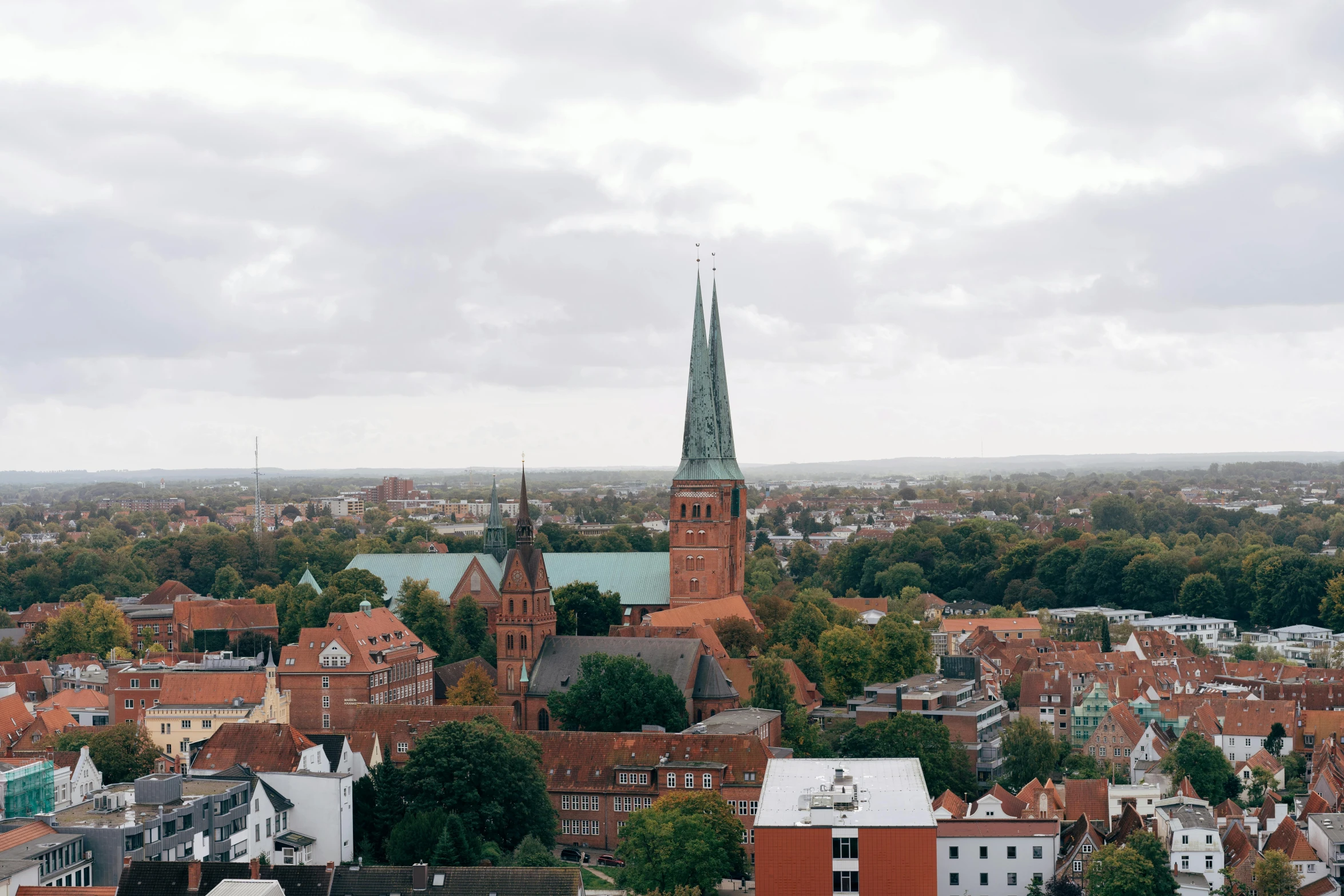 a cityscape with many red bricks and a green steeple