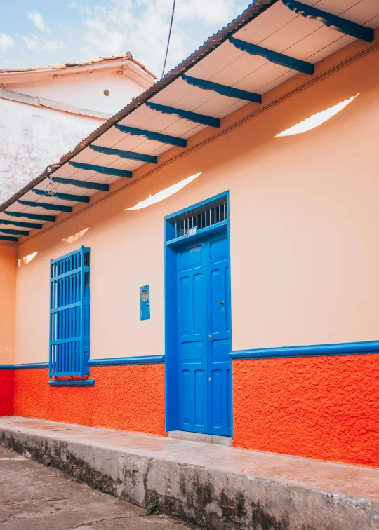 blue and orange painted doors and windows on side of building