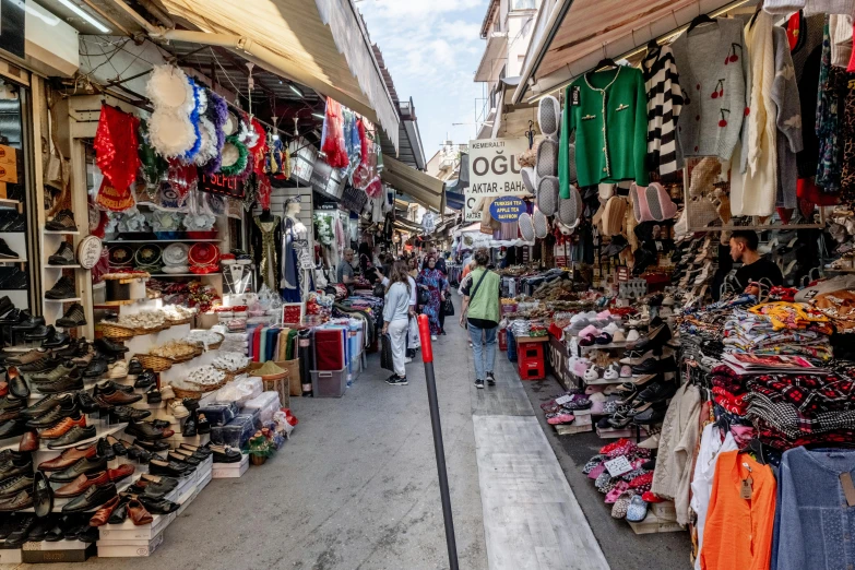 people walk by a clothing stall on the street