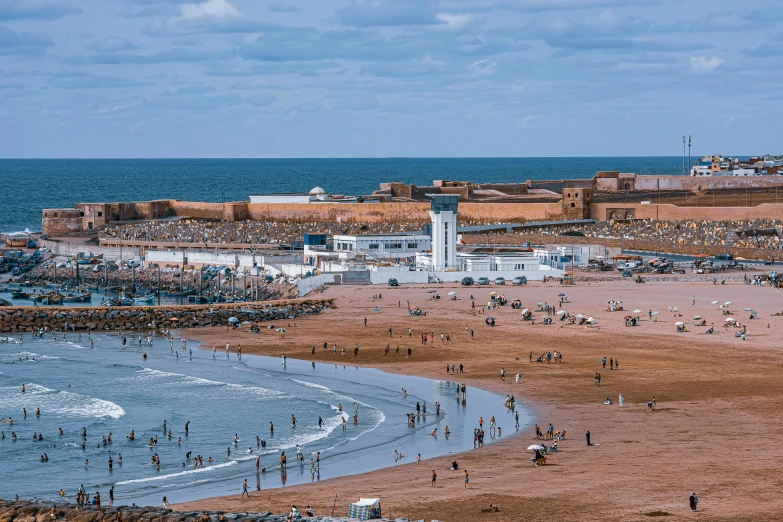 many people are gathered at a beach near the ocean