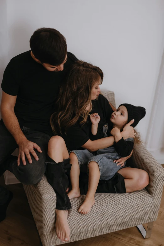 family of four sitting on couch with dog looking at camera