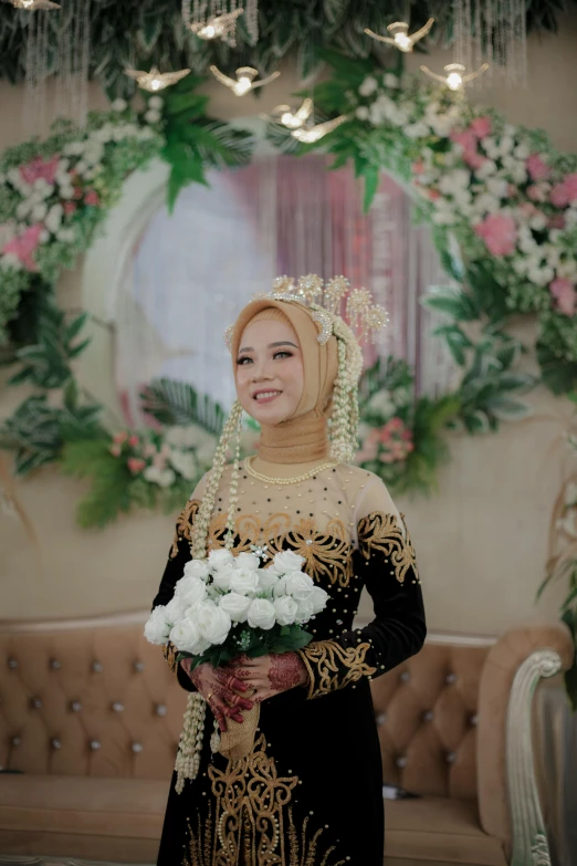 a woman is holding flowers and standing in a room