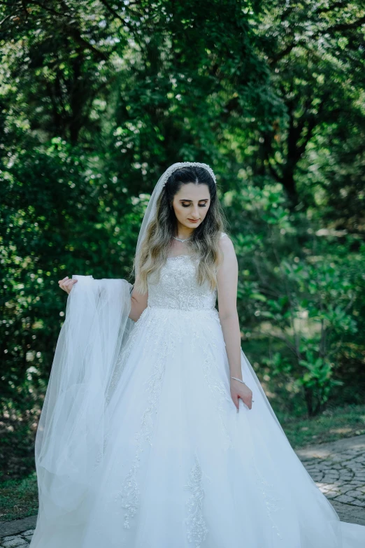 a woman in wedding dress holding a veil