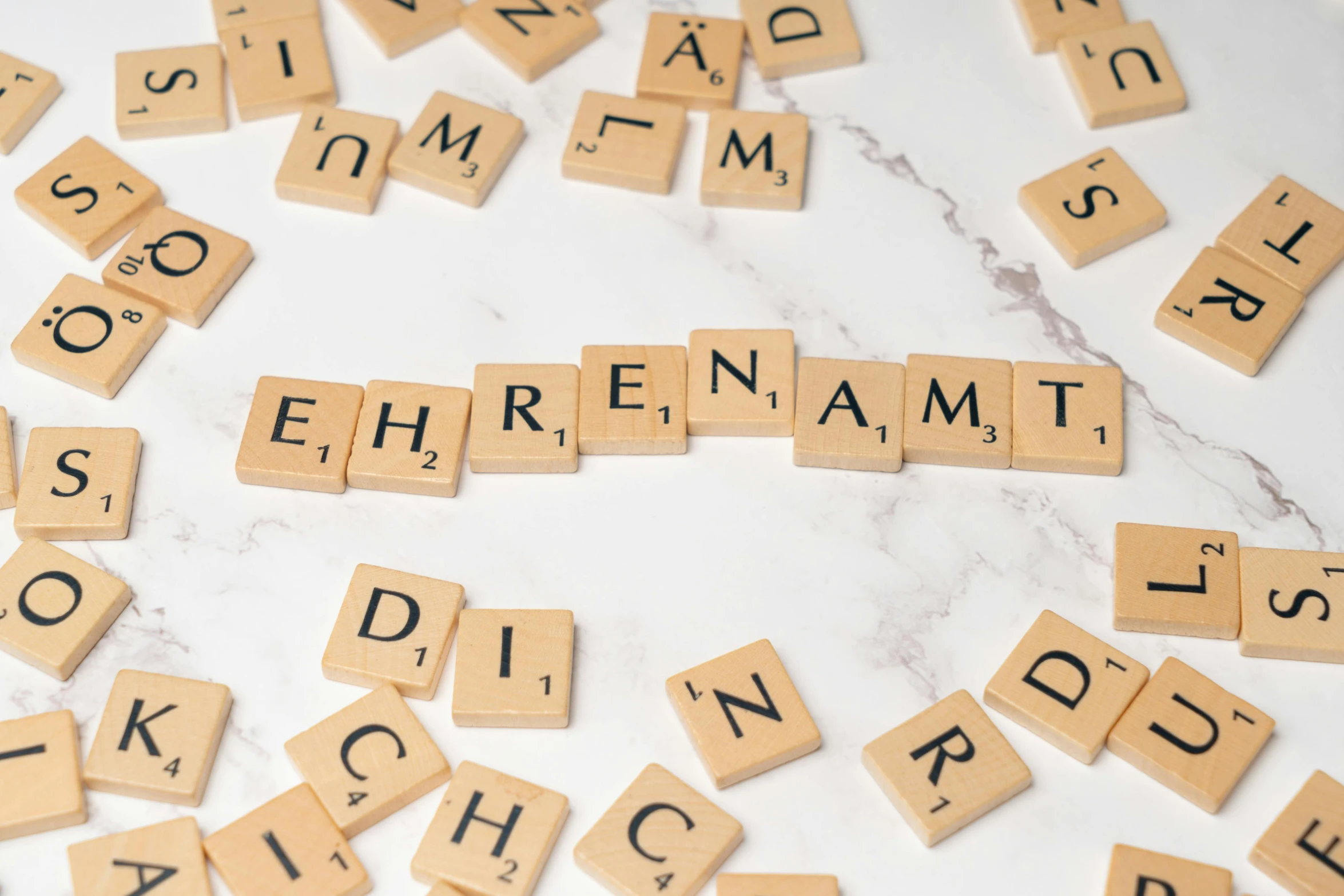 scrabbled letters spelling'ephrenament, diction, alphabet, and name spelled by letters on a marble background