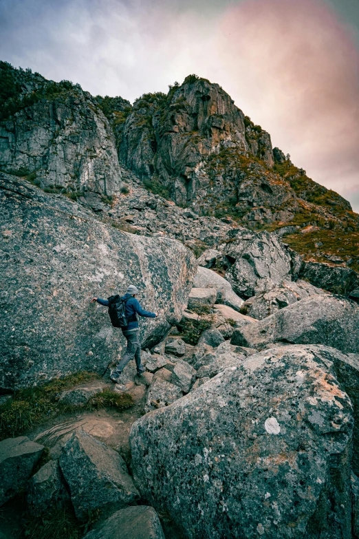 an adult hiker walking on rocky terrain in the mountains