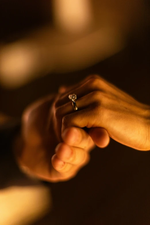 a couple holding hands close up with a wedding ring