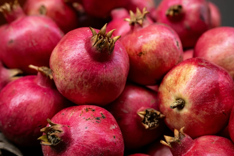 some fresh pomegranates are piled together